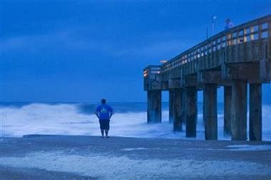 Stanley Sicinski looks at storm surf before sunrise in St. Augustine Beach, Florida, as Hurricane Sandy, which was downgraded to a tropical storm and upgraded again, passes offshore October 27, 2012.     Credit: Reuters/Steve Nesius