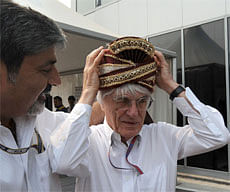 President of the Federation of Motor Sports Clubs of India (FMSCI) Vicky Chandhok (L) presents a turban to Formula One chief Bernie Ecclestone prior to The Formula One Indian Grand Prix 2012 at The Buddh International circuit in Greater Noida, on the outskirts of New Delhi on October 28, 2012. AFP PHOTO