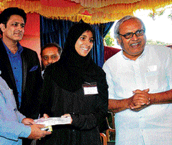 Kannada Development Authority chairperson Mukhyamantri Chandru greets Shaheena H S, a student of a PU&#8200; college in Aldur,&#8200;Chikmagalur district, at an event organised for distribution of scholarship to meritorious students in Kannada medium. DH Photo