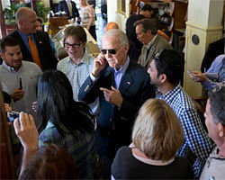 Vice President Joe Biden speaks on a patron's phone during a visit to the Station 400 restaurant, Wednesday, Oct. 31, 2012, in Sarasota, Fla., after a campaign stop. (AP Photo)