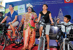 eco-friendly: Visitors to the Mysore Palace pedal to light up the Varaha Gate. dh photo