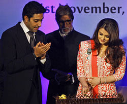 Bollywood actress Aishwarya Rai Bachchan, right, cuts her birthday cake as her husband actor Abhishek Bachchan, left and Amitabh Bachchan, center, look on during a function where she received the second highest French civilian award 'Officer Dan Ordre Arts et des Lettres', in Mumbai, on Thursday. AP