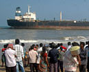 People gather to see an Indian ship Pratibha Cauvery which ran aground due to strong winds on the Bay of Bengal coast, near Marina beach in Chennai on Friday. PTI
