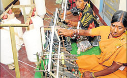 Women spin khadi yarn at the entrance of the expo. dh photo