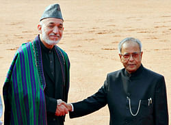 Afghanistan's President Hamid Karzai (L) shakes hands with his Indian counterpart Pranab Mukherjee during Karzai's ceremonial reception at the forecourt of India's presidential palace Rashtrapati Bhavan in New Delhi November 12, 2012. Afghanistan is 'ripe and ready' for Indian investments in mining and other sectors, Karzai told business leaders in Mumbai on Saturday at the start of a trip to woo investors for his war-ravaged country. REUTERS