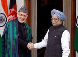 Afghanistans President Hamid Karzai, left, and Indian Prime Minister Manmohan Singh shake hands as they pose for photos before a meeting in New Delhi, India, Monday, Nov. 12, 2012. Karzai was meeting with Indian leaders Monday in a bid to woo investment to his war-torn country and boost security before a planned drawdown of NATO troops in 2014. AP