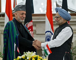Afghanistan President Hamid Karzai (L) shakes hands with Prime Minister Manmohan Singh after the signing of agreements in New Delhi on November 12, 2012. The Afgan President is on a five day state visit to India till November 13. AFP