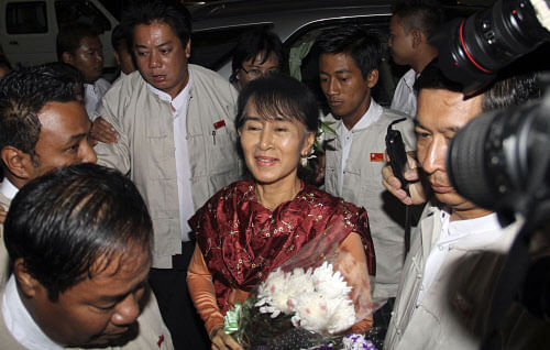 Myanmar opposition leader Aung San Suu Kyi, center, arrives at Yangon International airport before departing for India in yangon, Myanmar, Monday, Nov. 12, 2012. (AP Photo)