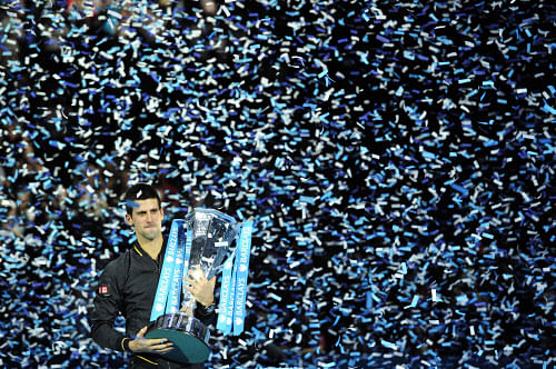 Serbia's Novak Djokovic poses with the winners' trophy after the singles final against Switzerland's Roger Federer on the eighth day of the ATP World Tour Finals tennis tournament in London on November 12, 2012. TOPSHOTS/AFP PHOTO/GLYN KIRK