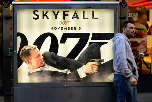 A man stands in front of a poster advertising the latest James Bond movie 'Skyfall' in New York on November 12, 2012. AFP