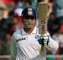 India's Virender Sehwag raises his bat after completing his half century on the opening day of the first cricket test match against England at Motera in Ahmedabad on Thursday. PTI Photo