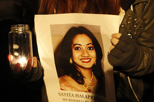 A woman holds a picture of Savita Halappanava during a candle lit vigil outside Belfast City Hall, Northern Ireland, Thursday, Nov. 15, 2012, for Savita Halappanavar, the 31-year old Indian woman who was 17-weeks pregnant when she died of blood poisoning after suffering a miscarriage in Galway, Ireland, on 28 October. Savita Halappanavar's father, Andanappa Yalagi, said the combination of medical negligence and Irish abortion laws led to his daughter's death. The parents of an Indian woman who suffered a miscarriage and died after being refused an abortion in an Irish hospital slammed Ireland's abortion laws Thursday. (AP Photo
