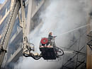 An Indian firefighter uses a hose in an attempt to control a fire that broke out in a fifteen story building in New Delhi early November 19, 2012. No casualities were reported in the fire. AFP