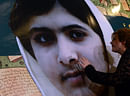 A Pakistani woman touches a photograph of Pakistan's child activist Malala Yousafzai during a ceremony to mark 'Malala Day' in Lahore on November 10, 2012. Pakistan marked 'Malala Day' Saturday on a global day of support for the teenager shot by the Taliban for promoting girls' education, but in her home town security fears meant schoolmates could not honour her in public. Nearly 100,000 people have signed an online petition calling for Malala to be nominated for the Nobel Peace Prize and on Friday UN special education envoy Gordon Brown handed a separate million-strong petition in support of Malala to Pakistani President Asif Ali Zardari. AFP PHOTO