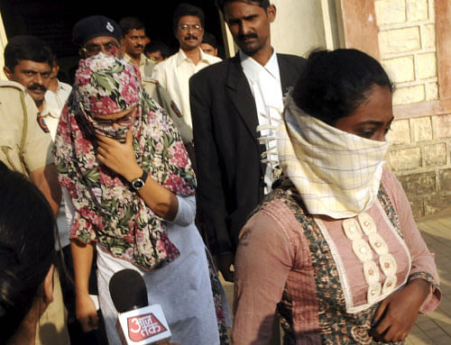 In this Monday, Nov.19, 2012 photo, face covered Shaheen Dhada, left, and Renu Srinivas, women arrested for their Facebook posts, come out of a court in Mumbai, India, Tuesday, Nov. 20, 2012. AP