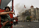 FILE- In this Nov. 29, 2008 file photo, an Indian soldier takes cover as the Taj Mahal hotel burns during a gun battle between Indian military and militants inside the hotel in Mumbai, India. India executed the lone surviving gunman from the 2008 terror attack on Mumbai early Wednesday, Nov. 21, 2012, India's home ministry said. Ajmal Kasab, a Pakistani citizen, was one of 10 gunmen who rampaged through the streets of India's financial capital in November 2008, killing 166 people. Kasab was hung at a jail in Pune, a city near Mumbai, after India's president rejected his plea for mercy. (AP