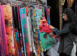 Shop: A woman checks out hand-painted stoles at the souq.