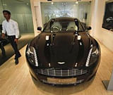 An employee walks past an Aston Martin Rapide inside the company's showroom in Mumbai January 2, 2012.  Credit: Reuters