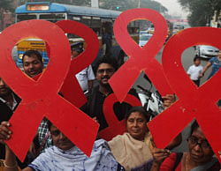 Volunteers and the members of a social organisation holds ribbon shaped placards for an HIV/AIDS awareness messages during rally in Kolkata on November 30, 2012, on the eve of World AIDS Day. The UNAIDS agency says some 2.5 million Indians are living with HIV, many of them ostracised by their communities. AFP