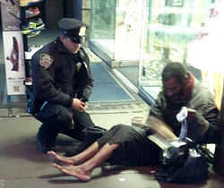 This photo provided by Jennifer Foster shows New York City Police Officer Larry DePrimo presenting a barefoot homeless man in New York's Time Square with boots Nov. 14, 2012 . Foster was visiting New York with her husband on Nov. 14, when she came across the shoeless man asking for change in Times Square. As she was about to approach him, she said the officer came up to the man with a pair of all-weather boots and thermal socks on the frigid night. She took the picture on her cellphone. It was posted Tuesday night to the NYPD's official Facebook page and became an instant hit. More than 350,000 users 'liked' it as of Thursday afternoon, and over 100,000 shared it. AP