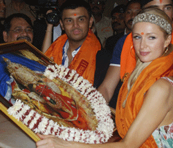 Socialite Paris Whitney Hilton poses with a photograph of an idol of Lord Ganesha during her visit to a temple in Mumbai on December 3, 2012. The American heiress had been invited to take part in the India Resort Fashion Week in Goa over the weekend. AFP photo