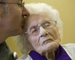 In this March 10, 2011 file photo, Besse Cooper, 114, right, receives a kiss from her grandson Paul Cooper, 42, during a ceremony in which Guinness World Records recognizes her as the word's oldest living person, at the nursing home where she lives in Monroe, Ga. Besse Cooper, the woman who was listed as the world's oldest person has died Tuesday, Dec. 4, 2012 in a Georgia nursing home at age 116, according to her son Sidney Cooper.  AP