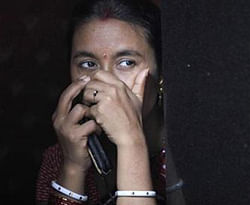 A sex worker watches a Raksha Bandhan festival celebration in a red light area in Mumbai.  Credit: Reuters
