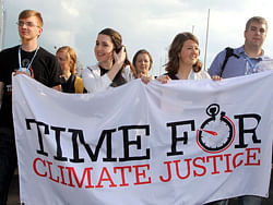 Activists carry placards during a rally in Doha on December 1, 2012 to demand urgent action addressing climate change as the United Nations Convention on Climate Change continues in the Qatari capital. The chances of hitting the UN's global warming target are diminishing, but the goal can still be met if greenhouse-gas emissions fall by 15 percent by 2020, scientists said. AFP