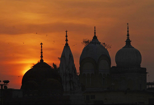 Birds fly at sunset over a Hindu temple on the 20th anniversary of the Babri mosque demolition in Ayodhya, India, Thursday, Dec. 6, 2012.