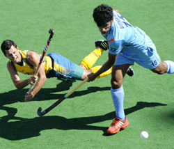 Luke Dwyer of Australia, left, dives as he takes a strike on goal under pressure from Uthappa SK of India during their semifinal game at the Men's Hockey Champions Trophy in Melbourne, Australia, Saturday, Dec. 8, 2012. AP photo