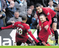 first strike Manchester Uniteds Wayne Rooney (centre) celebrates with Robin van Persie (right) and Ashley Young after scoring his teams first goal against Manchester City. AP