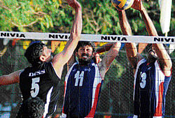 hard-hitting DYSS Pruthviraj (left) attempts to smash past BSNLs TB Ravindra (right) and Maruthi G Nayak during their Karnataka Volley League match on Wednesday. DH PHOTO