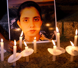 A student of a nursing college places a candle in front of a picture depicting nurse Jacintha Saldanha, during a candle-lit vigil organized by a local politician in Bangalore, India, Thursday, Dec. 13, 2012. An inquest into the apparent suicide of Saldanha, who was duped by a hoax call from Australian DJs about the pregnant Duchess of Cambridge, heard Thursday that she was found hanging in her room, had wrist injuries and left three notes. (AP Photo