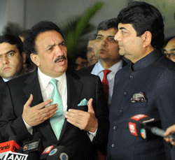 Interior Minister of Pakistan Rehman Malik (C) gestures while speaking as Kunwar Ratanjit Pratap Narain Singh (2R), Indian Minister of State in Home Affairs, looks on after Malik arrived at an Indian Air Force station in New Delhi on December 14, 2012. Pakistan's interior minister flew to India to launch a new agreement aimed at lowering hurdles in cross-border travel between the two nuclear-armed rival countries, officials said. AFP PHOTO