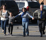 In this photo provided by the Newtown Bee, a police officer leads two women and a child from Sandy Hook Elementary School in Newtown, Conn., where a gunman opened fire, killing 26 people, including 20 children, Friday, Dec. 14, 2012. AP Photo