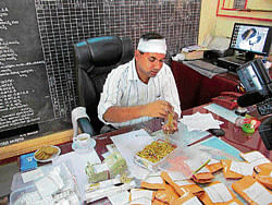 The Booty: Superintendent of Police Sandeep Patil examines gold bars and ornaments seized from three men in  Belgaum on Friday. dh photo