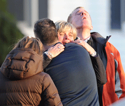 Unidentified people embrace on December 14, 2012 at the aftermath of a school shooting at a Connecticut elementary school that brought police swarming into the leafy neighborhood, while other area schools were put under lock-down, police and local media said. Local media quoted that the gunman had died at the Sandy Hook Elementary School in Newtown, Connecticut, northeast of New York City. At least 27 people, including 18 children, were killed on Friday when at least one shooter opened fire at an elementary school in Newtown, Connecticut, CBS News reported, citing unnamed officials. AFP PHOTO