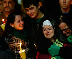 Donna Soto (R), mother of Victoria Soto, the first-grade teacher at Sandy Hook Elementary School who was shot and killed while protecting her students, hugs her daughter Karly (second from right) while mourning their loss with Victoria's other two siblings, Jillian (far left) and Matthew Soto (second from left), at a candlelight vigil at Stratford High School on December 15, 2012 in Stratford, Connecticut. Twenty-six people were shot dead, including twenty children, after a gunman identified as Adam Lanza opened fire in the school. Lanza also reportedly had committed suicide at the scene.  AFP photo