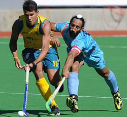 Joel Carroll of Australia, left, and Sardar Singh of India fight for the ball during their semifinal game at the Men's Hockey Champions Trophy in Melbourne, Australia, Saturday, Dec. 8, 2012. Australia defeated India 3-0. (AP Photo