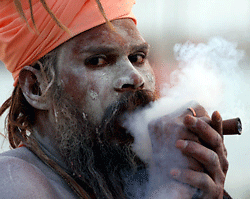 A Sadhu of Shri Panch Dashanaam Juna Akhara smokes a 'chillum' on his arrival at Sangam to participate in the upcoming Maha Kumbh Festival in Allahabad on December 12, 2012. The Kumbh Mela is the largest gathering of people for a religious purpose in the world and millions of people gather for this auspicious occasion. AFP PHOTO/ Sanjay Kanojia