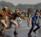 An Indian protester is chased by a police officer during a protest in New Delhi, India, Saturday, Dec. 22, 2012. Police used tear gas and water cannons to push back thousands of people who tried to march to the presidential mansion to protest the recent gang rape and brutal beating of a 23-year-old student on a moving bus. (AP Photo)