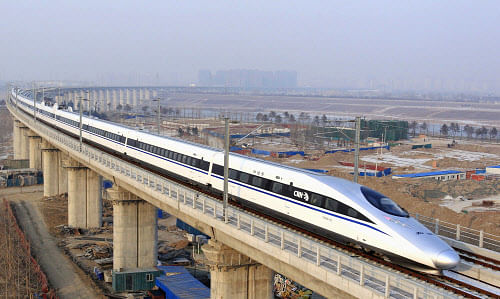 In this photo released by China's Xinhua news agency, a bullet train passes over Yongdinghe Bridge in Beijing Wednesday, Dec. 26, 2012. China has opened the world's longest high-speed rail line, which runs 2,298 kilometers (1,428 miles) from the country's capital in the north to Guangzhou, an economic hub in the Pearl River delta in southern China. (AP Photo/Xinhua, Jiao Hongtao)