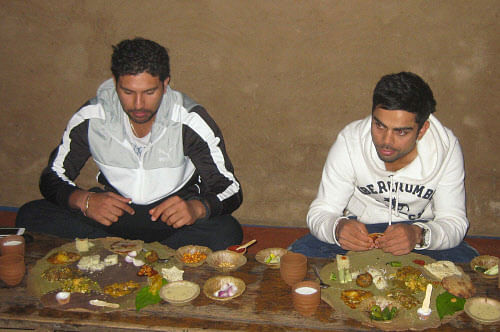 Indian cricketers Yuvraj Singh and Virat Kohli having traditional Gujarati food at a restaurant in Ahmedabad on Thursday. PTI Photo