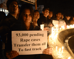 A protester hold candles and posters during a rally in Ahmedabad on December 30, 2012, following following the cremation of a gangrape victim in the Indian capital. The victim of a gang-rape and murder which triggered an outpouring of grief and anger across India was cremated at a private ceremony, hours after her body was flown home from Singapore. A student of 23-year-old, the focus of nationwide protests since she was brutally attacked on a bus in New Delhi two weeks ago, was cremated away from the public glare at the request of her traumatised parents. AFP