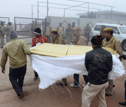 Relatives and policemen carry coffin of Delhi gang rape victim at a cremation ground in New Delhi on Sunday. PTI