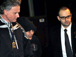 In this Saturday, Dec. 29, 2012 photo, New York City Police Department detectives escort Erika Menendez, second from left, out of the 112th Precinct in the Queens borough of New York. Menendez was arraigned Saturday night on a charge of murder as a hate crime. Judge Gia Morris has ordered that the 31-year-old be held without bail and be given a mental health exam. AP
