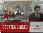 In this photograph taken on October 20, 2012, an Indian customer service representative stands inside the closed window of a Kingfisher Airlines booking counter at Indira Gandhi International Airport in New Delhi. India's troubled Kingfisher Airlines has lost its permit to fly after a deadline to renew its suspended licence expired, the national aviation regulator said January 1, 2013. AFP PHOTO