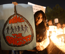 Indian protesters hold candles and posters during a rally in Ahmedabad on December 30, 2012, following following the cremation of a gangrape victim in the Indian capital. The victim of a gang-rape and murder which triggered an outpouring of grief and anger across India was cremated at a private ceremony, hours after her body was flown home from Singapore. A student of 23-year-old, the focus of nationwide protests since she was brutally attacked on a bus in New Delhi two weeks ago, was cremated away from the public glare at the request of her traumatised parents. AFP PHOTO