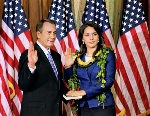 Democratic Congresswoman from Hawaii, Tulsi Gabbard, being administered the oath of office by the Speaker of the US House of Representatives John Boehner in Washington on Friday. Gabbard took the oath on a personal copy of her Bhagavad Gita. PTI Photo