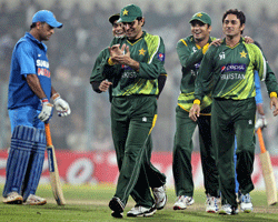 Pakistani players celebrate the fall of an Indian wicket as skipper MS Dhoni looks on during the 2nd ODI cricket match at Eden Garden in Kolkata on Thursday. PTI Photo